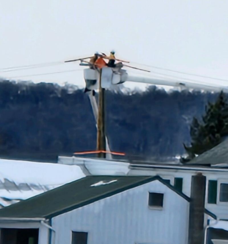 Two Men in a Bucket Truck in a Snow Storm